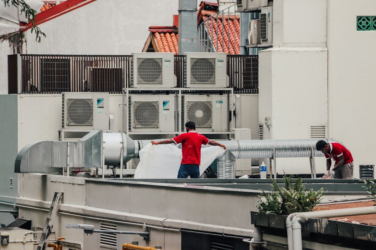 Technicians servicing rooftop HVAC equipment