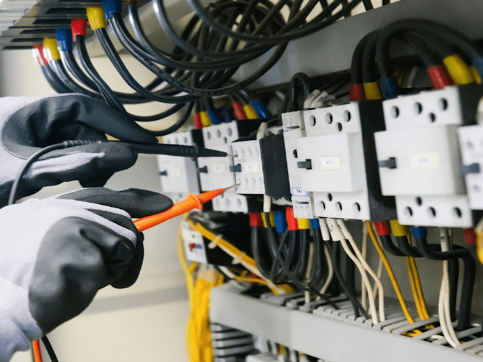 Technician testing an electrical panel with a multimeter